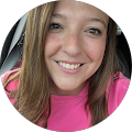 young, smiling woman with long brunette hair and a pink shirt