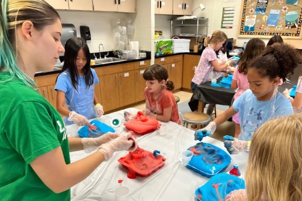 group of kids and an instructor playing with a messy material