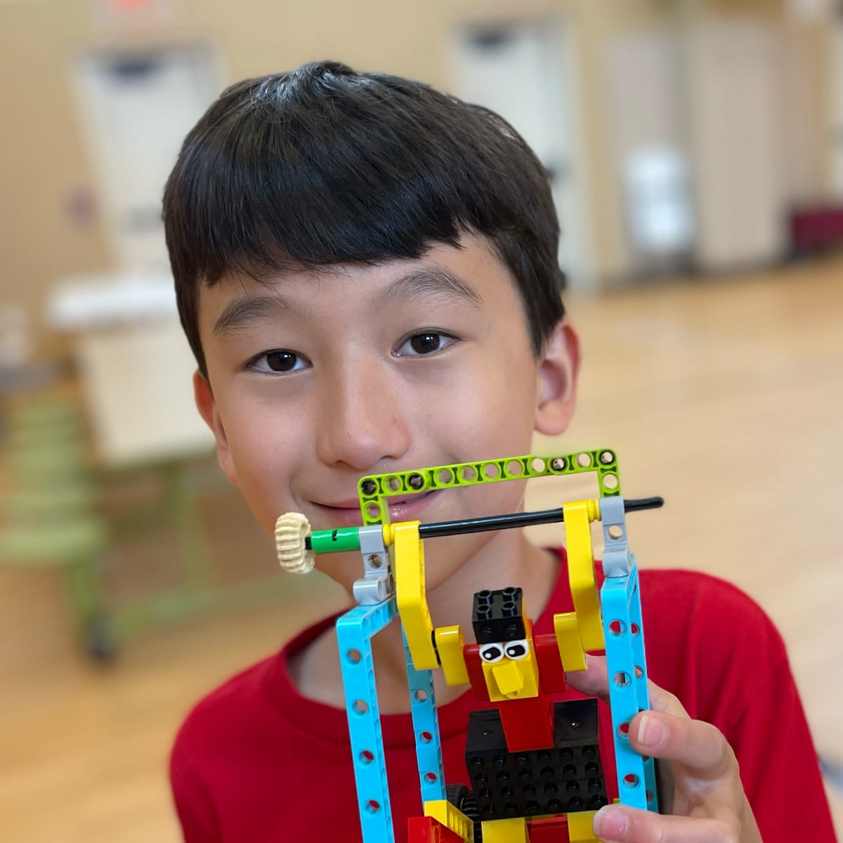 boy holding up a LEGO robot model