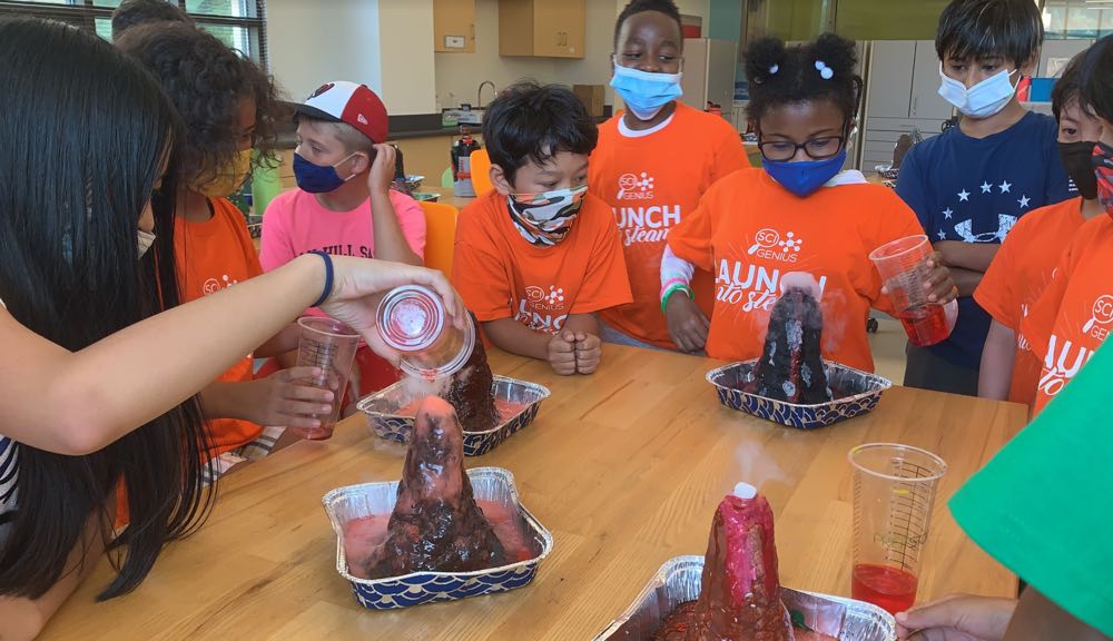group of campers doing a volcano science experiment