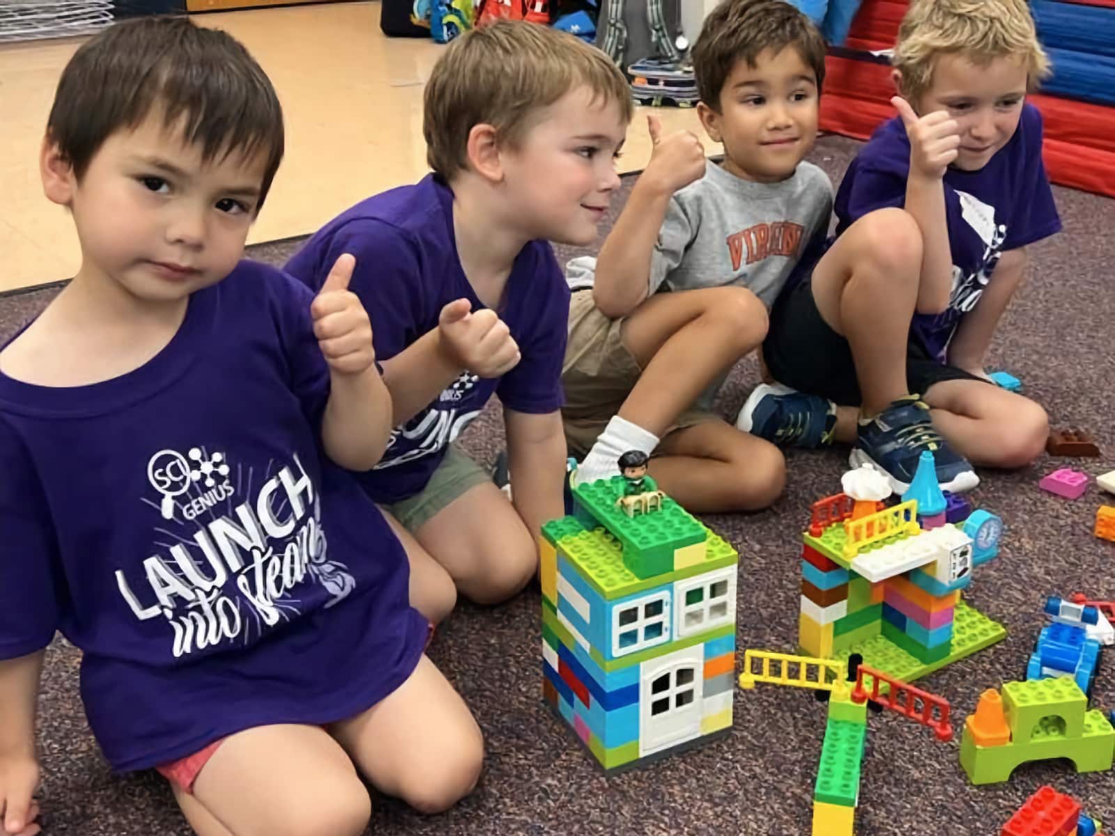 A group of young boys building with LEGO Duplo