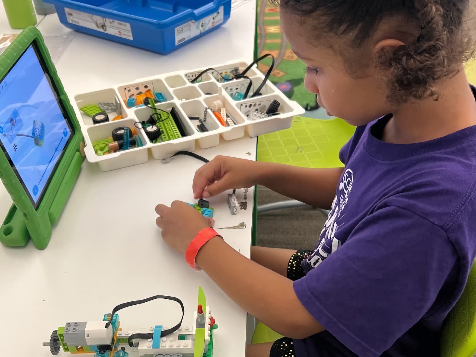 young girl building a LEGO robot