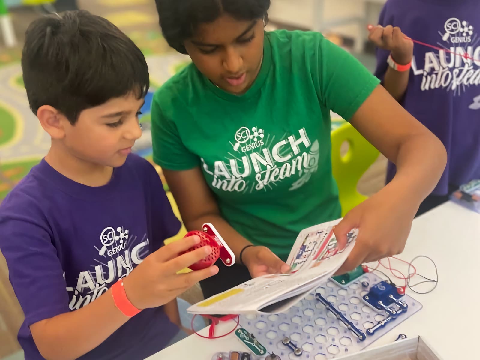 instructor helping camper with snap circuits