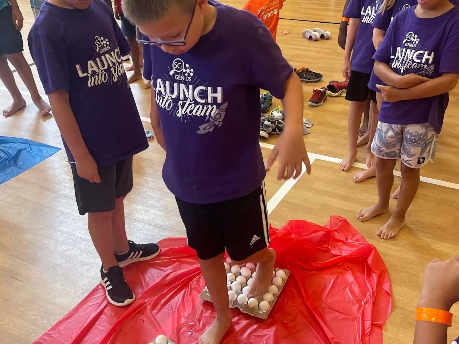 group of kids stepping on eggs in cartons on the floor