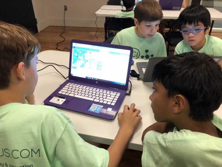 young campers on laptops coding and programming