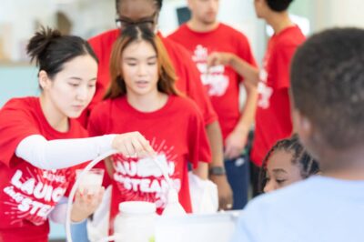 group of summer camp counselors conducting experiment for kids