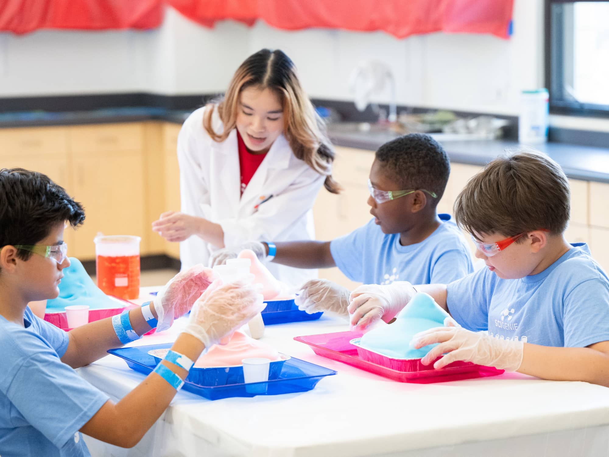 science teacher conducting experiment with group sitting at a table