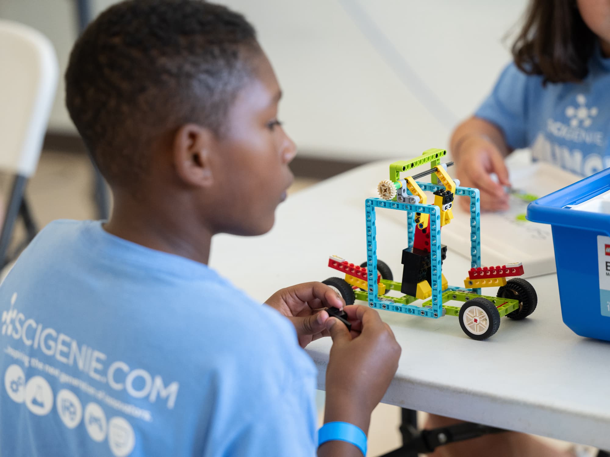 boy creating a robotic vehicle using LEGO BricQ bricks