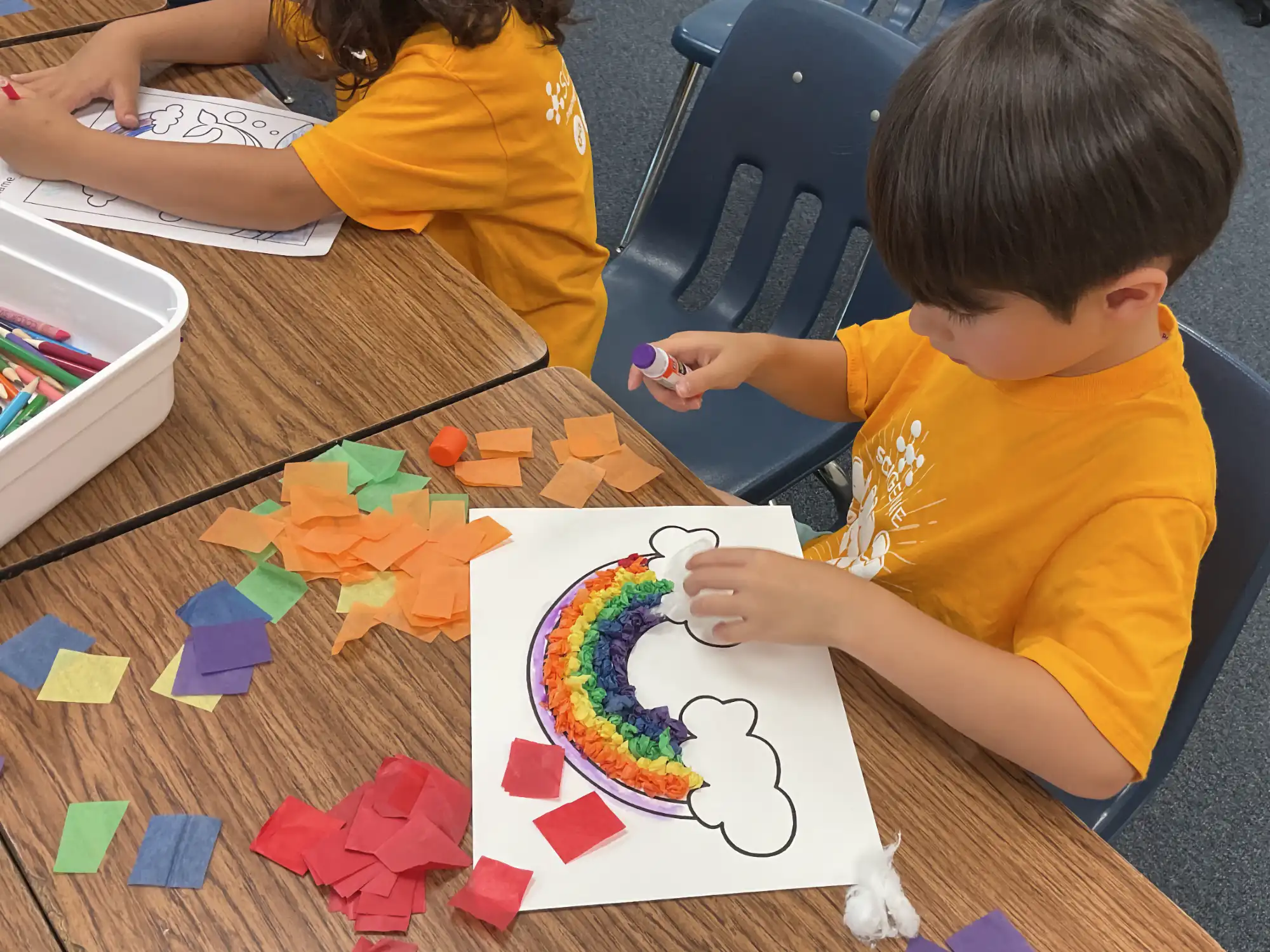 Young camper working on a rainbow art project.