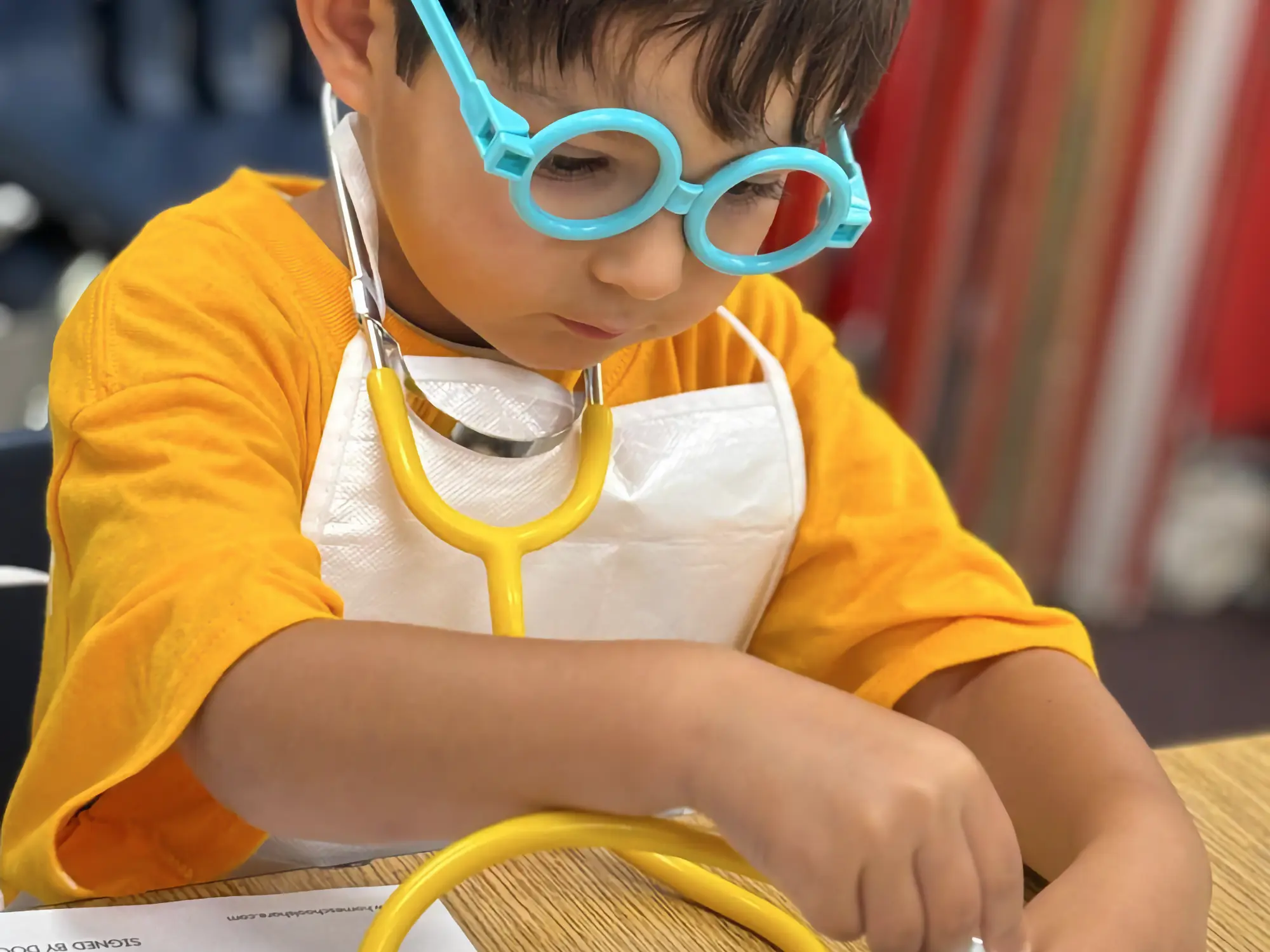 A young camper wearing doctors glasses and a stethoscope.