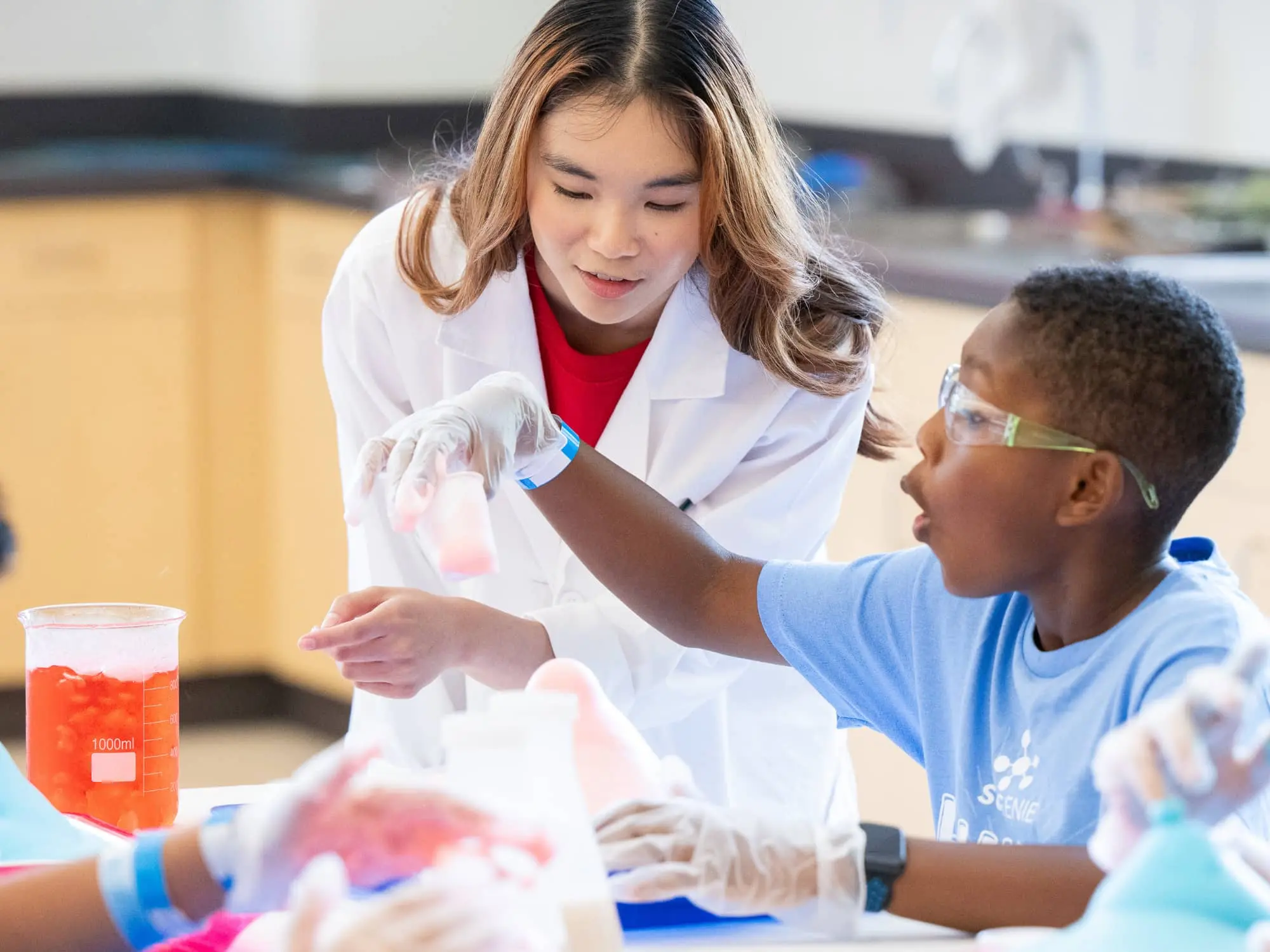 Science teacher conducting experiment with camper in awe of results.