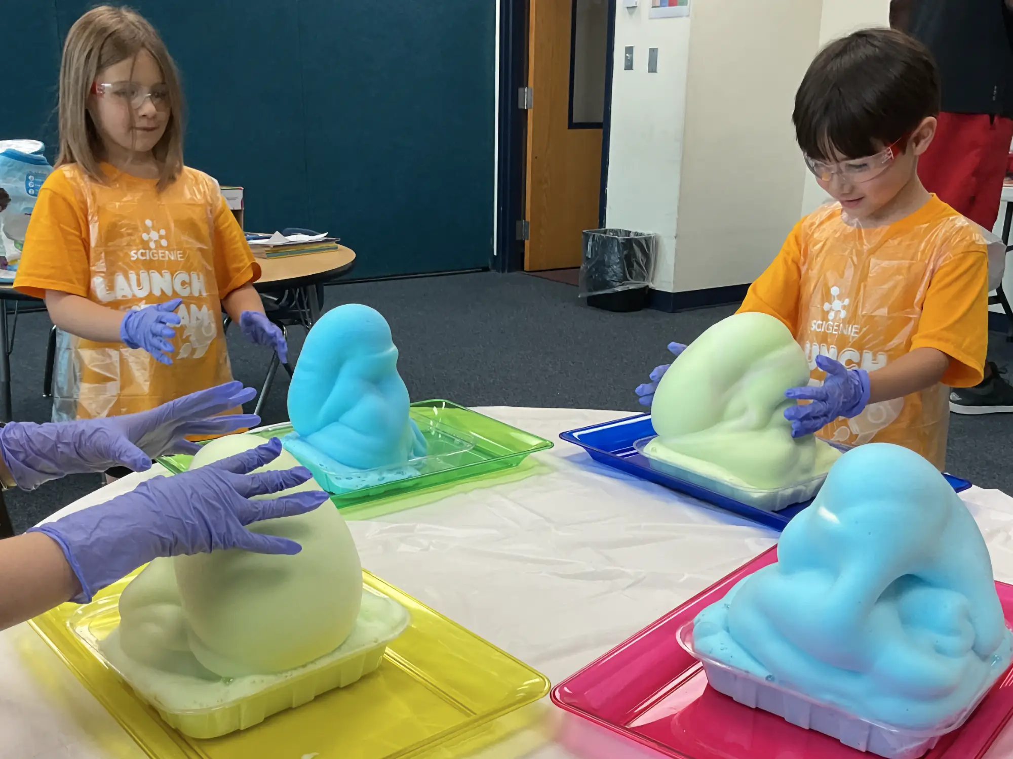 Young campers playing with foam from a science experiment.