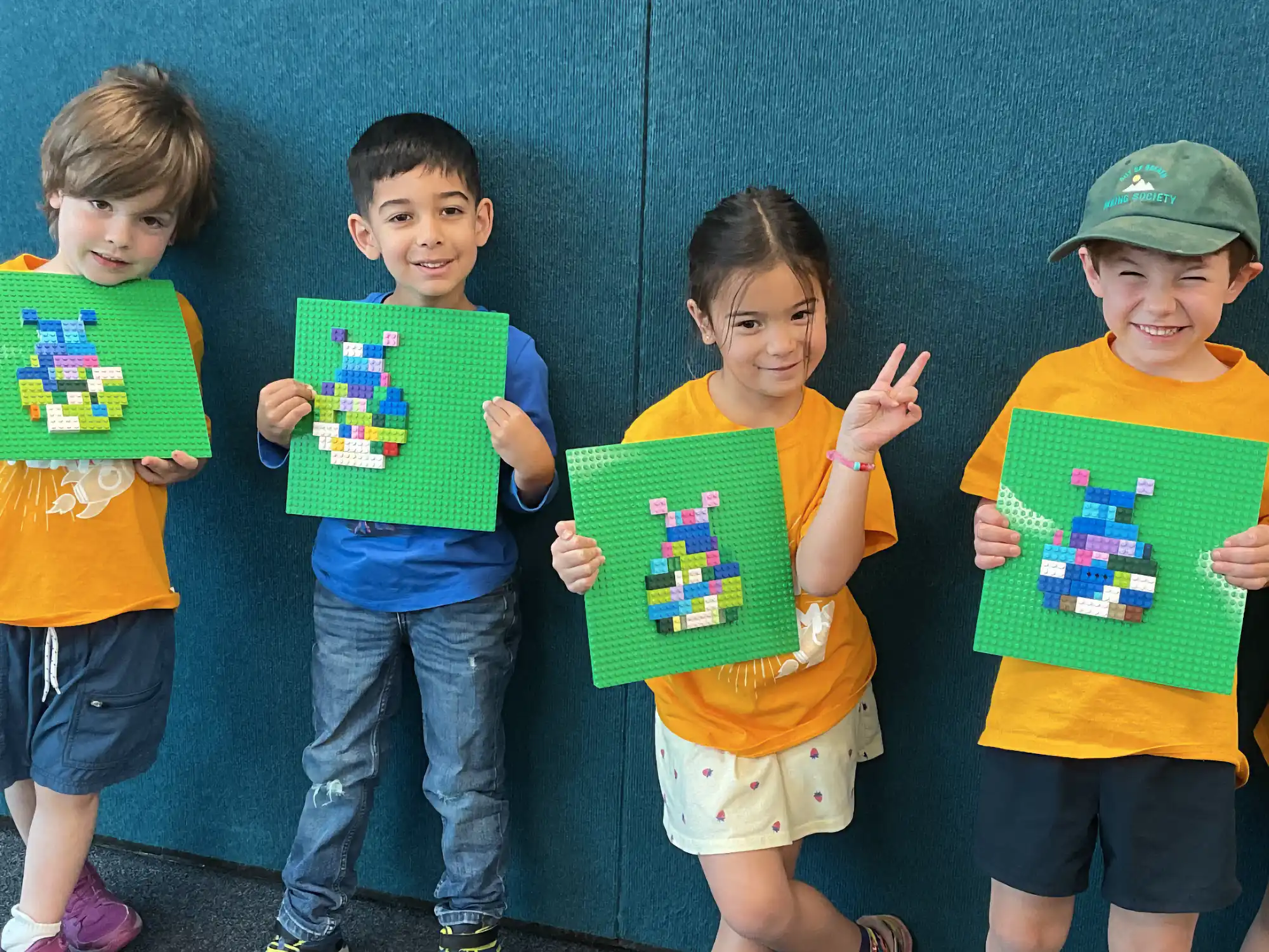 Young campers holding up their lego art.