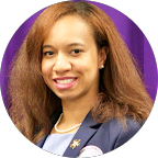 Dr. Kendra Jenkins smiles confidently, wearing a dark blazer, pearl necklace, and earrings. She has long brown hair and is featured in a professional headshot.